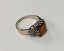 A garnet and diamond single stone ring in claw mou