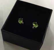 A pair of peridot single stone ear studs. Est. £40