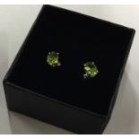 A pair of peridot single stone ear studs. Est. £40