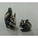 A pair of silver figures of squirrels in seated po