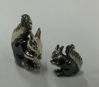 A pair of silver figures of squirrels in seated po