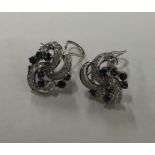 A pair of large sapphire and diamond scroll decora