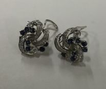 A pair of large sapphire and diamond scroll decora