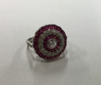 A circular ruby and diamond three row cluster ring