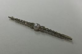 A large pearl and diamond brooch with rubover moun