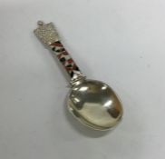 A silver and enamel caddy spoon of tapering form.