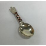 A silver and enamel caddy spoon of tapering form.