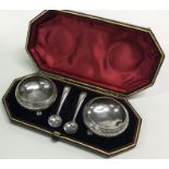 A boxed pair of chased silver salts together with