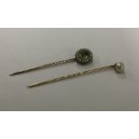 An Antique pearl mounted stick pin together with a