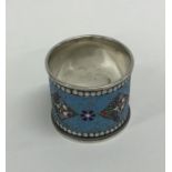 A large silver and enamelled napkin ring with ball