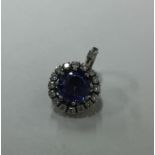 A fine tanzanite and diamond circular pendant, the