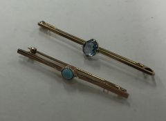 A gold blue stone brooch together with one other.