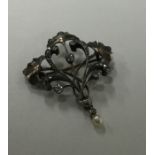 A diamond and pearl brooch in the form of a leaf w