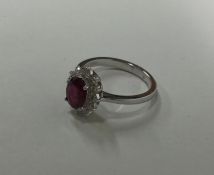 An attractive ruby and diamond oval daisy head clu