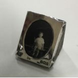 A miniature silver photograph frame on wooden stan