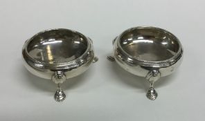 A pair of circular Georgian silver salts on cabrio