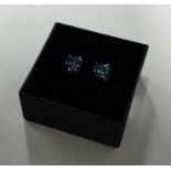 A pair of blue topaz ear studs in claw mounts. Est