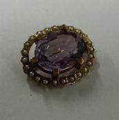 An 18 carat amethyst and pearl brooch in claw moun