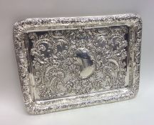 An Edwardian chased silver dressing table tray. Bi