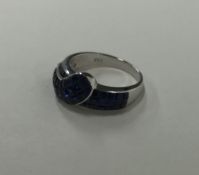 An unusual sapphire and diamond buckle shaped ring