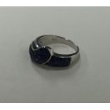 An unusual sapphire and diamond buckle shaped ring