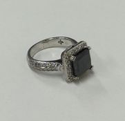 A large princess cut black diamond cluster ring in