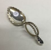 A large silver gilt and enamel caddy spoon with sw