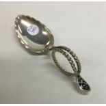 A large silver gilt and enamel caddy spoon with sw