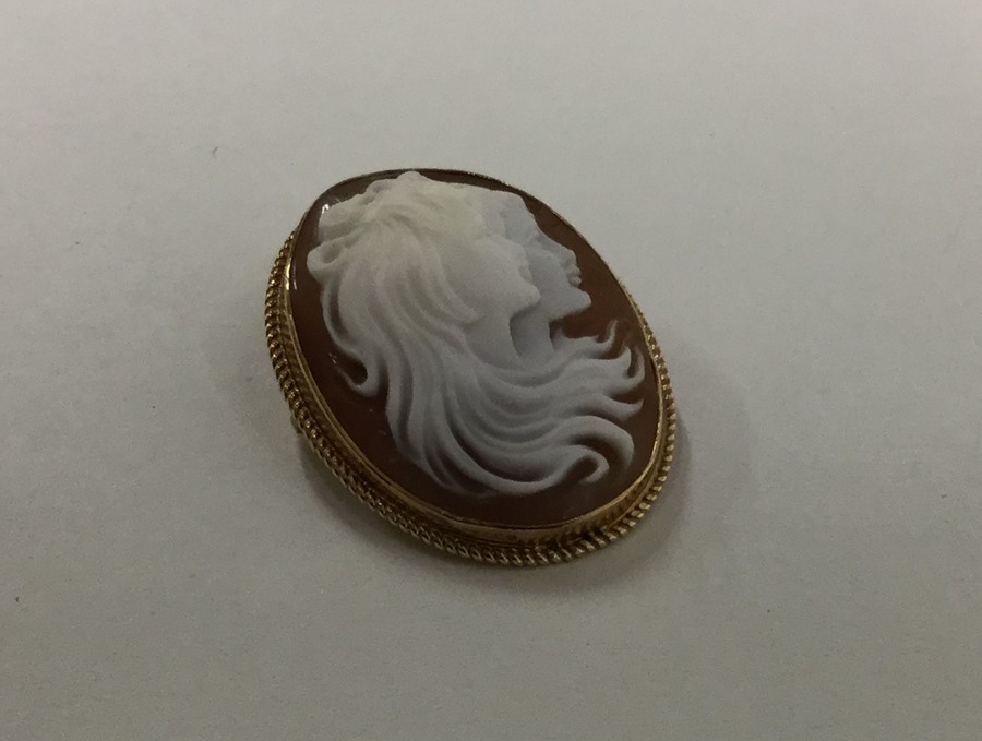 A 9 carat oval cameo with rope twist border. Appro