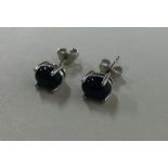 A pair of black opal ear studs contained within a