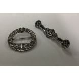 A silver Celtic brooch together with one other. Ap
