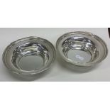 A good pair of modern silver wine coasters on red