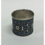 A large silver and enamelled napkin ring with ball