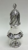 A tall silver sugar caster of half fluted design.