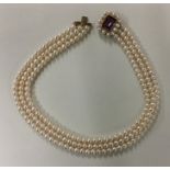 A cased gold mounted and pearl three row choker wi