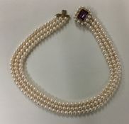 A cased gold mounted and pearl three row choker wi