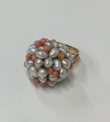 A coral and pearl ring in gold mount. Approx. 9.2