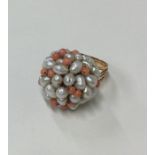 A coral and pearl ring in gold mount. Approx. 9.2