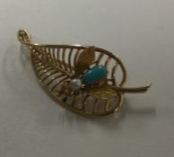 An unusual pearl and turquoise brooch in the form