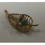 An unusual pearl and turquoise brooch in the form