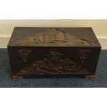 A small carved camphor wood trunk with hinged top.