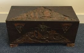 A small carved camphor wood trunk with hinged top.