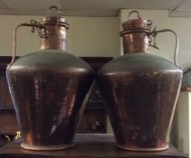 A pair of tall tapering copper urns with lift-off