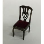 A small silver model of a chair. Approx. 6.2 grams