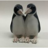 A Royal Copenhagen figure of a pair of penguins. E