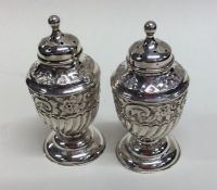 A pair of small half fluted silver sugar casters o