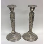 A pair of Chinese white metal candlesticks of tape
