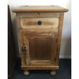 A stripped pine hinged top cupboard on four bun fe