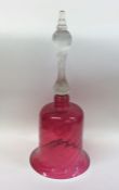 An Antique cranberry glass bell with tapering spir