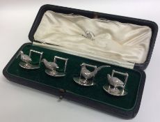 A good set of four cast silver menu holders in the